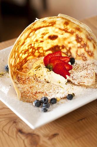 Crepe with sliced strawberries and blueberries