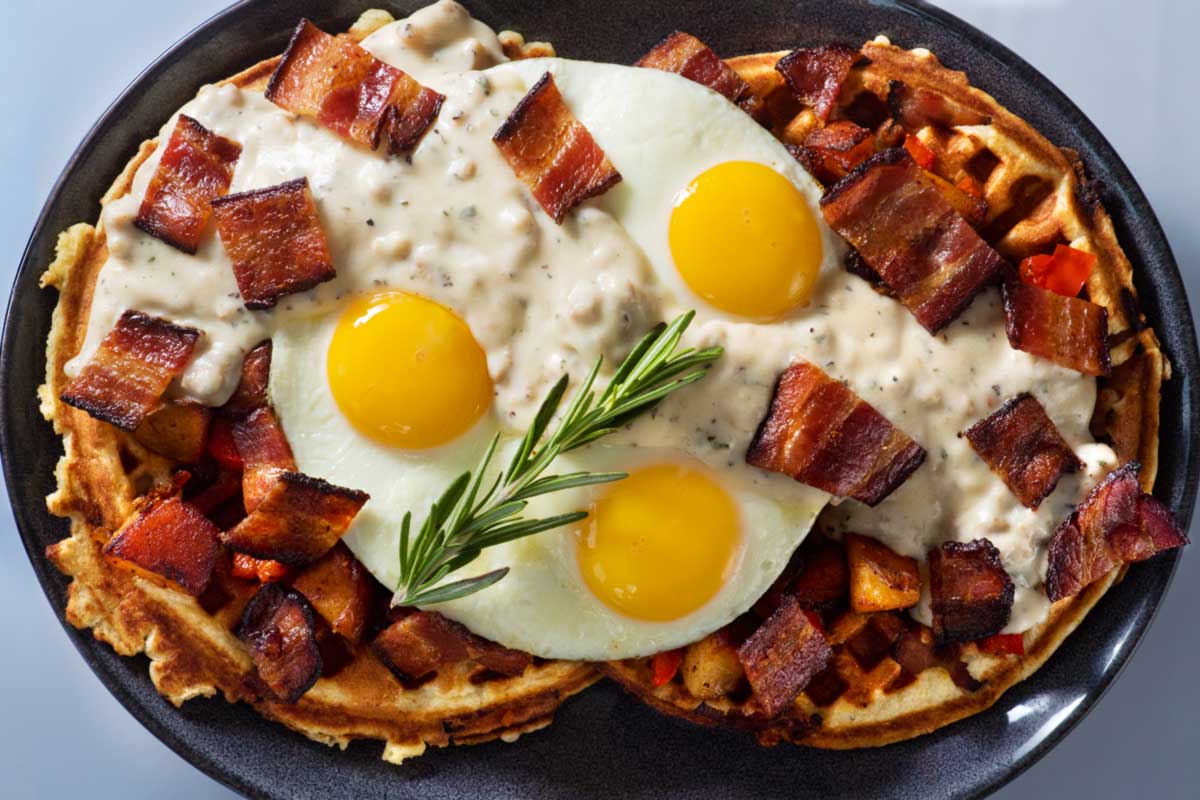 Eggs and bacon on waffles with sauce