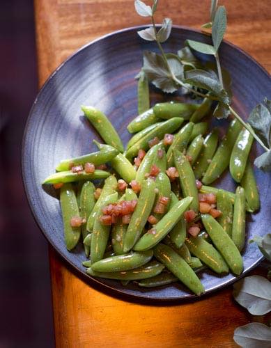 Steamed pea pods in a blue bowl with garnish