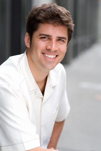 Shows a professional headshot of a business coach, man, casual, half body, outside